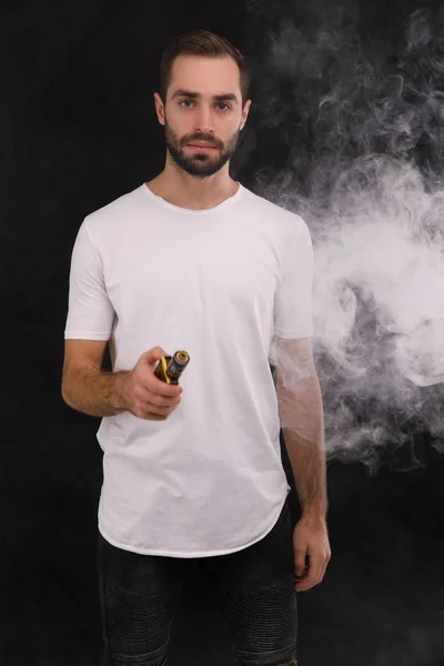 A srác a fehér póló, fekete alapon, egy elektronikus cigaretta — Stock Fotó