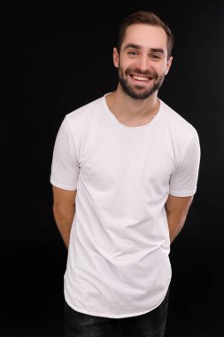 Siyah bir arka plan üzerinde beyaz bir T-shirt neşeli adam