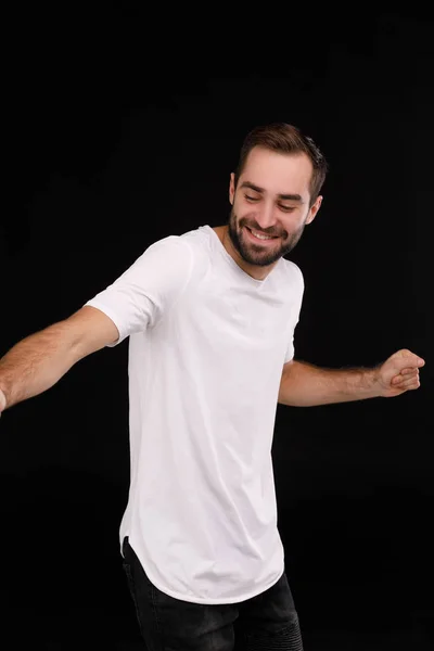 Cara alegre em uma camiseta branca em um fundo preto — Fotografia de Stock