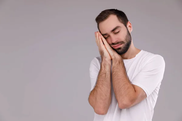 Homem com uma barba em uma camiseta branca em um fundo cinza — Fotografia de Stock