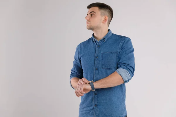 Bonito homem em uma camiseta azul em branco isolado no fundo branco — Fotografia de Stock