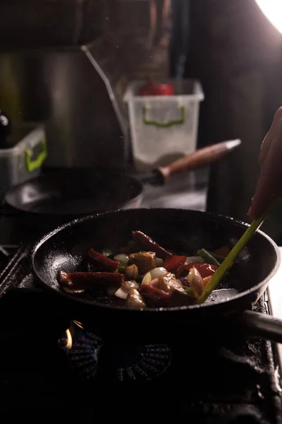 Šéfkuchař v restauraci Kitchen připravuje jídlo tmavé pozadí — Stock fotografie