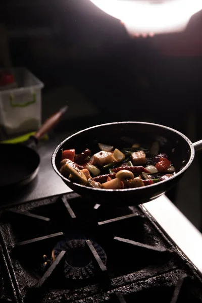 Šéfkuchař v restauraci Kitchen připravuje jídlo tmavé pozadí — Stock fotografie