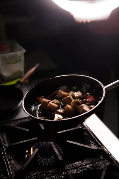 Šéfkuchař v restauraci Kitchen připravuje jídlo tmavé pozadí — Stock fotografie