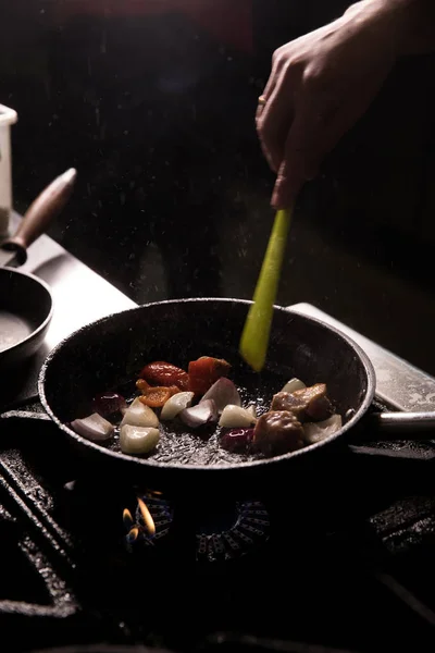 Šéfkuchař v restauraci Kitchen připravuje jídlo tmavé pozadí — Stock fotografie