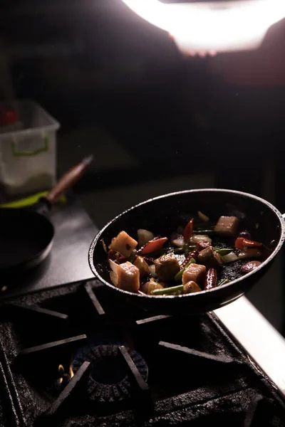 Šéfkuchař v restauraci Kitchen připravuje jídlo tmavé pozadí — Stock fotografie