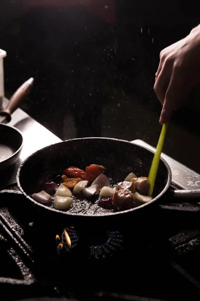 Šéfkuchař v restauraci Kitchen připravuje jídlo tmavé pozadí — Stock fotografie