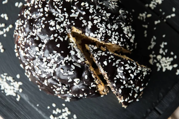Torta al cioccolato con un pezzo tagliato e lama su sfondo grigio, primo piano — Foto Stock