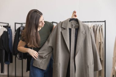 Bir genç kız bir giyim mağazası bir kat seçer.