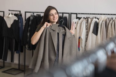 Bir genç kız bir giyim mağazası bir kat seçer.