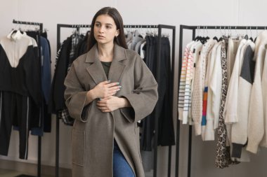 Bir genç kız bir giyim mağazası bir kat seçer.