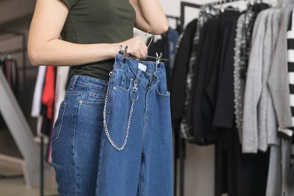 Дівчина в магазині вибирає джинси . — стокове фото