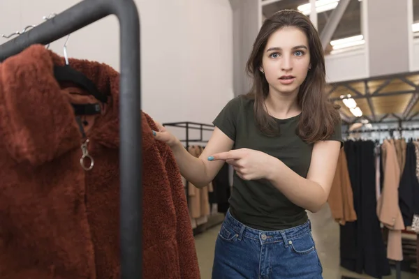Дівчина в магазині одягу вибирає нову шубу . — стокове фото