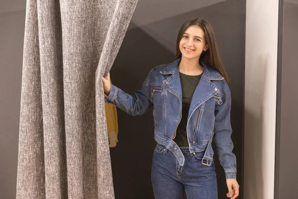 Chica joven se prueba la chaqueta de mezclilla en el vestidor . — Foto de Stock