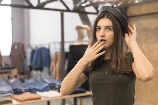 Tatlı bir kızın bir şapka üzerinde çalışırken bir giyim mağazası. — Stok fotoğraf