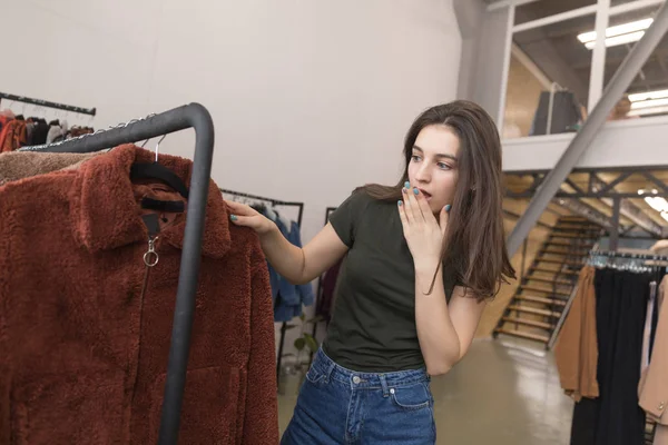 Дівчина в магазині одягу вибирає нову шубу . — стокове фото