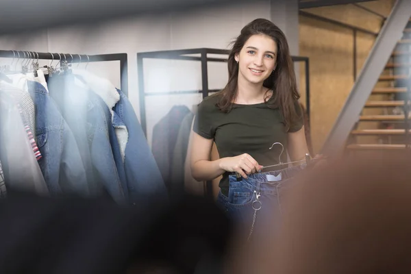 The girl in the store chooses his jeans. — Stock Photo, Image