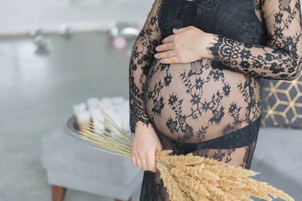 Mulher grávida em um belo vestido de renda mantém a barriga — Fotografia de Stock