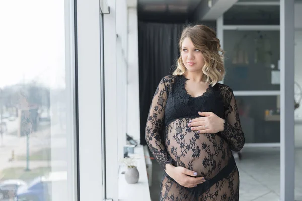 Hamile kadın güzel dantel elbise göbek tutar — Stok fotoğraf