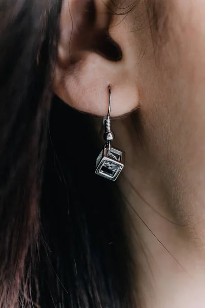 A close-up of a diamond earring in the shape of a diamond in the inside of a pebble. Precious decoration.