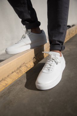 Modele beyaz ayakkabılarla yaklaş.