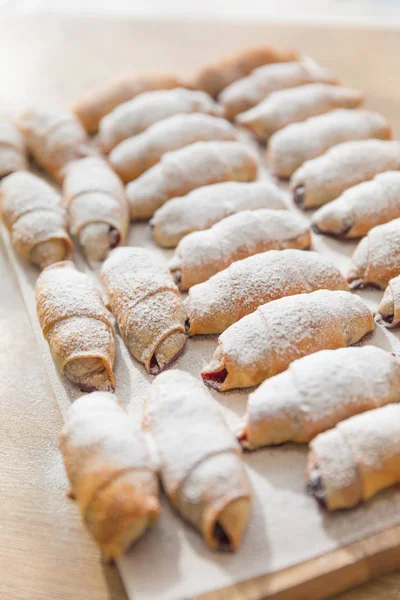 Fresh tasty pastries and desserts on wooden background.Sweet pastries, puff pastry, powdered sugar,assortment of pastries