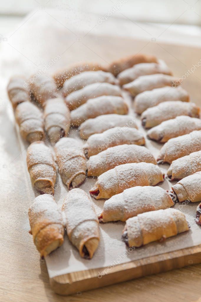 Fresh tasty pastries and desserts on wooden background.Sweet pastries, puff pastry, powdered sugar,assortment of pastries