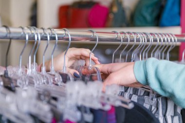 Askıları ile bir raf üzerinde bir adam ve bir kız elini yakın.