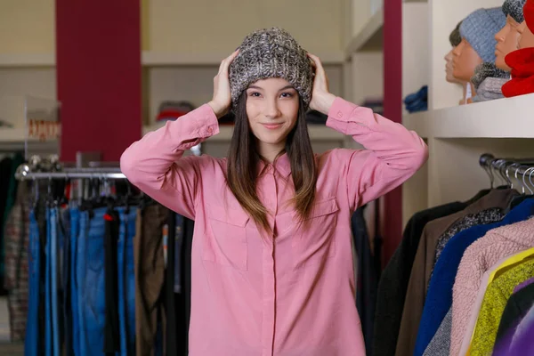 Дівчина в магазині вимірює шапку — стокове фото