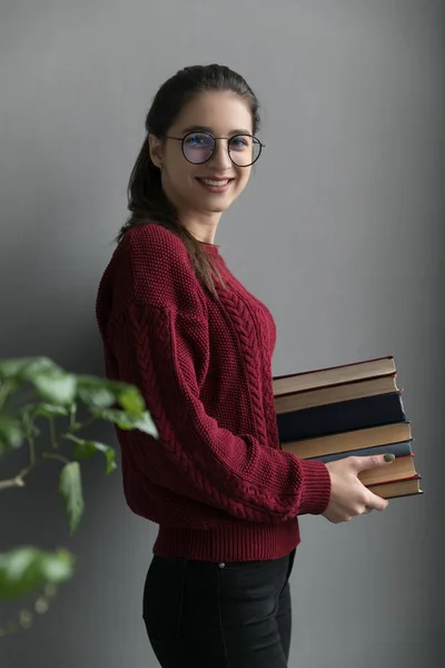 Encerramento Uma Menina Com Cabelos Coletados Fundo Cinza Segurando Livros Fotografia De Stock