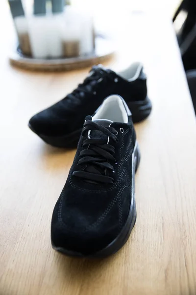 Ζευγάρι μαύρα αθλητικά παπούτσια σε διαφορετικά υπόβαθρα. κλείσιμο εικόνας — Φωτογραφία Αρχείου