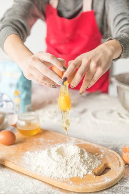 Pişirme konsepti. Rustik ahşap masa üzerinde gemide un ve yumurta sarısı, pişirme malzemeleri.