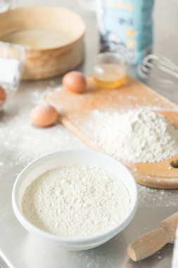 Pişirme konsepti. Rustik ahşap masa üzerinde gemide un ve yumurta sarısı, pişirme malzemeleri.