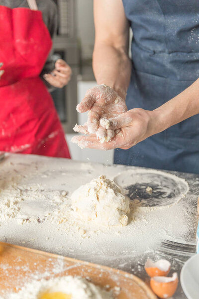 man and woman hands dough in the kitchen