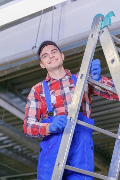 Primer plano de un electricista en una escalera reparando el cableado . — Foto de Stock