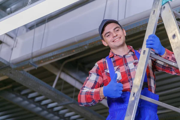 Primer plano de un electricista en una escalera reparando el cableado . — Foto de Stock