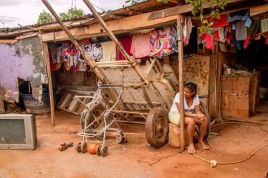 Planaltina, Gois, Brazil-December 08 2018: A young girl sits outside her home in Planaltina,Gois near the capital city of Brasilia  clipart