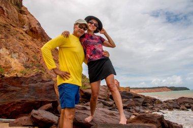 Kayaların üzerinde duran plajda eğlenmek çift