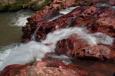 Bir akış kırmızı kayaların üzerinden acele su