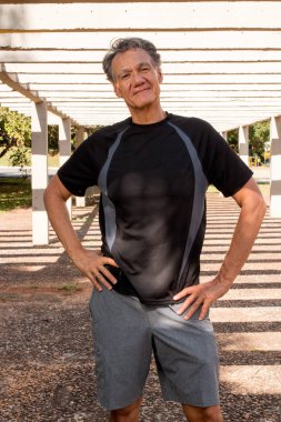 Siyah T-Shirt ve Gri Şort Rahatlatıcı Giyen Bir Orta Yaşlı Olgun Adam Dış Portresi