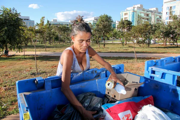 Brasilia, D.F., Brezilya- 11 Haziran 2019: Fakir genç bir anne, çocuklarını beslemek için para kazanmak için başkent Brasilia'nın varlıklı bir semtinde çöpleri kazıyor.. 