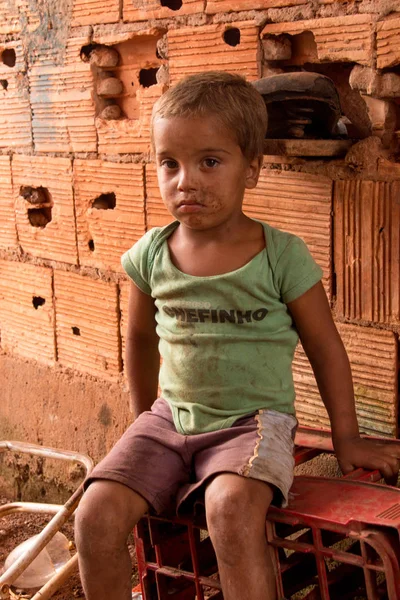 Planaltina, Goias, Brezilya-28 Nisan 2018: Yoksul şehir Planaltina'daki evinin önünde oturan küçük bir çocuk.