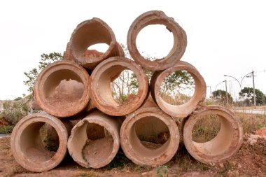 Lağım boruları birikmiş ve toprak bir yolun kenarına yığılmış.