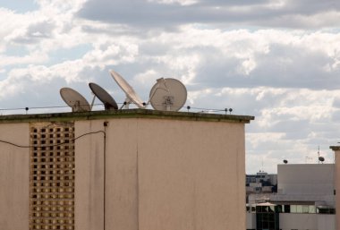 Televizyon antenleri apartmanların tepesinde duruyor. 