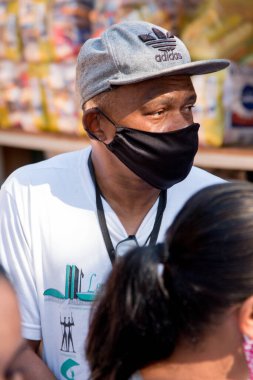 Planaltina, Goias, Brezilya-25 Temmuz 2020: Yoksullar için bir gıda dağıtım merkezinde koruyucu maske takan adam 