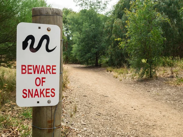 Bir toprak yol Hawthorn, Melbourne, Avustralya Yarra Nehri boyunca bir yılan uyarı işareti