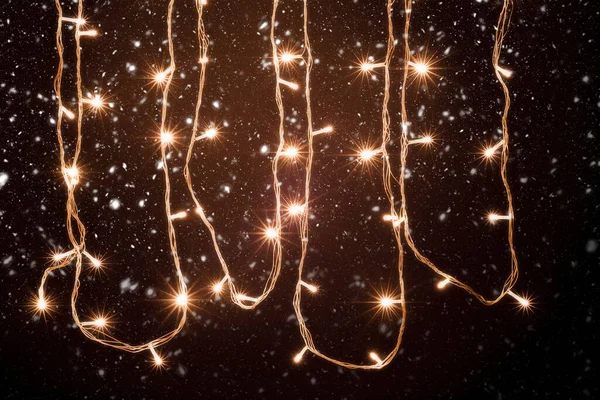 Noel ve Yeni Yıl Dekorasyon Işıkları, Kar Altında Çelenk Küçük Önde Parlayan Lambalar Siyah Arkaplanda.