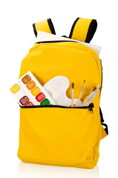 Sırt çantasında farklı okul kağıtları var. Beyaz arka planda izole edilmiş. Okul konsepti fotoğrafına dönelim..