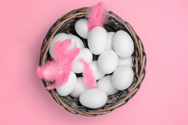 Białe Jaja Wiklinowym Koszu Piórami Papierowym Tle Jeden Symboli Wielkanocy — Zdjęcie stockowe