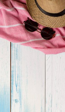 Ahşap yüzeyde şapka, havlu ve güneş gözlüğü. Üst Manzara. Yaz tatili konsepti. Beyaz arkaplanda izole.